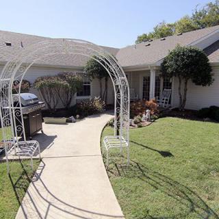 A well-maintained garden with a pathway leading to the house on a sunny day.