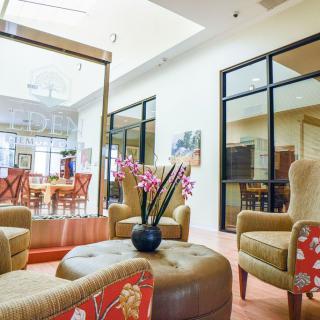 A cozy lobby with comfortable chairs and a floral centerpiece.