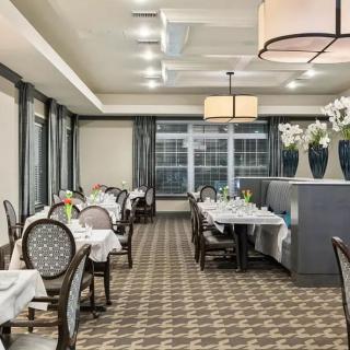 An elegantly decorated restaurant dining room with neatly arranged empty tables.