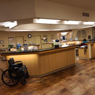 A view of a hospital nurse station with a wheelchair nearby.