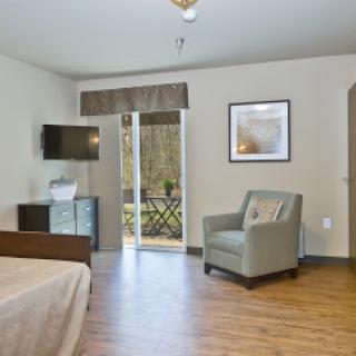 A cozy hotel room featuring modern furniture and natural light.