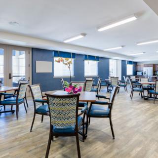 A modern dining area with neatly arranged tables and chairs.
