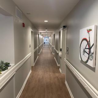 A well-lit residential hallway featuring decorative wall art of a bicycle.