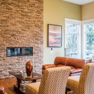 A cozy living room with a stone fireplace and comfortable seating.