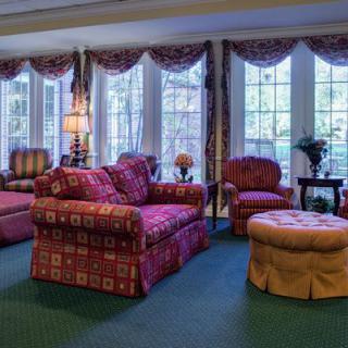 A cozy living room with patterned furniture and large windows.