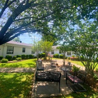 A sunny outdoor seating area surrounded by lush greenery, perfect for relaxation and enjoying nature.