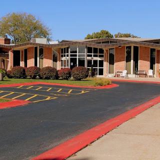A modern building with an inviting entrance and well-maintained landscaping on a clear day.
