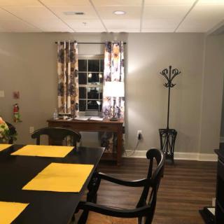 A cozy dining room with a table set for a meal and warm lighting.