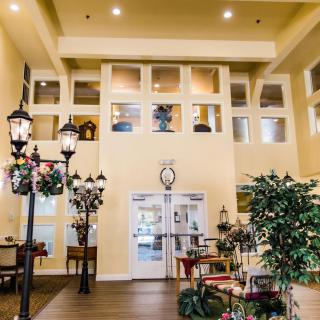 A warmly lit lobby with decorative street lamps, plants, and comfortable seating.