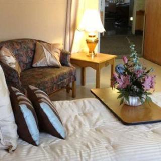 A cozy bedroom with a floral arrangement, sofa, and warm lighting.