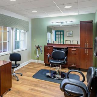 A well-lit hair salon interior featuring chairs, mirrors, and professional styling equipment.