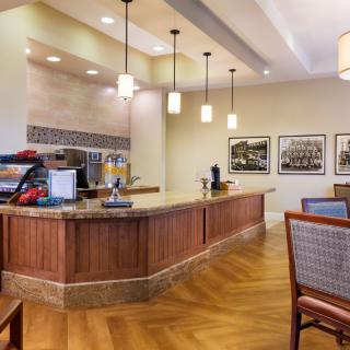 A modern indoor coffee station with a countertop, seating area, and ambient lighting.