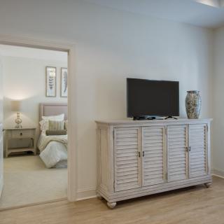 A modern living area featuring a stylish cabinet with a TV, seamlessly connected to a bedroom.