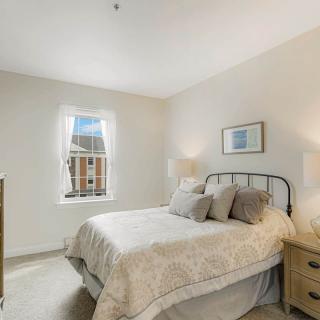 A cozy bedroom with a double bed, two bedside tables with lamps, and a window allowing natural light.