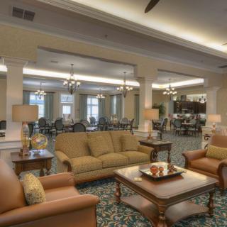 A spacious and well-furnished living room with sofas, chairs, and a coffee table.