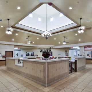 A spacious reception area with overhead lighting and tiled flooring.