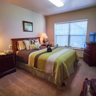 A cozy bedroom with a neatly made bed, nightstands, and soft lighting creating a warm ambiance.