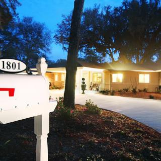 A cozy house with a mailbox labeled '1801' at dusk.