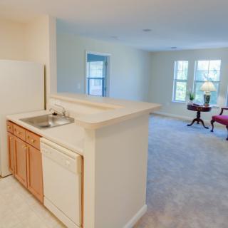 A bright and open apartment with a small kitchen and a spacious living area.