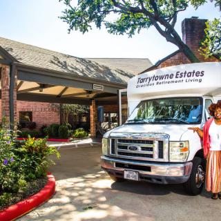 A retirement community entrance with a transportation van parked outside.
