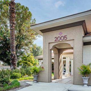 A modern house entrance with well-maintained landscaping and trees.