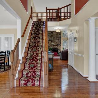 Elegant home interior featuring a wooden staircase with a patterned carpet runner.
