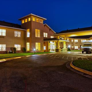 A well-lit building exterior at night, showcasing hotel architecture and entrance.