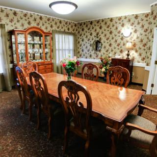 A beautifully arranged dining room featuring an elegant wooden table and chairs, adorned with floral wallpaper.