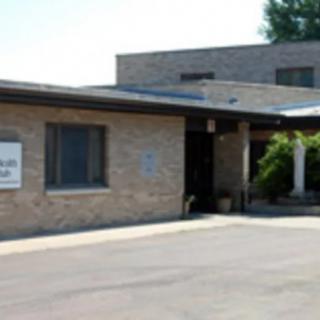 A view of a brick building with an entrance, possibly a clinic or office.