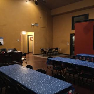 An empty room set up with tables and chairs, ready for an event or meeting.