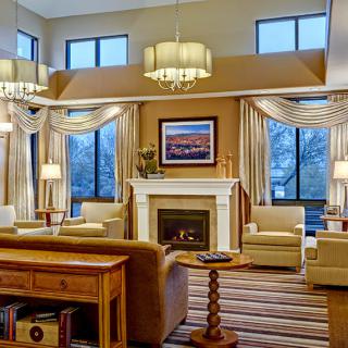 A cozy and elegantly designed living room with a fireplace, large windows, and stylish lighting.
