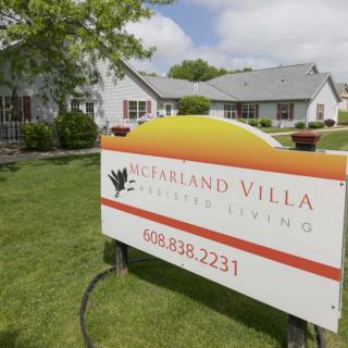Sign for McFarland Villa Senior Living in front of residential buildings.
