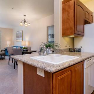 A cozy kitchen and dining area featuring wooden cabinets, a sink, and a well-lit space.