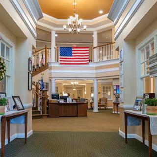 Elegant lobby with a large American flag, chandelier, and welcoming reception area.