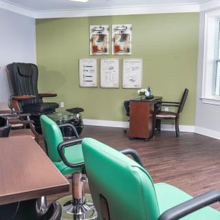 A cozy office space with green chairs, wood flooring, and decorative wall art.
