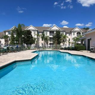 A sunny day at a residential apartment complex featuring a large outdoor swimming pool.