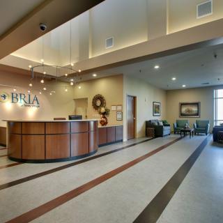 A modern and well-lit reception area with a curved desk and comfortable seating.