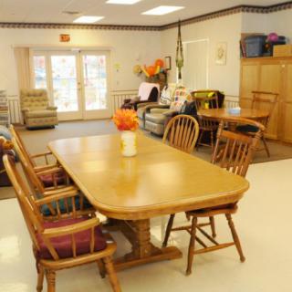 A community center dining room with a large wooden table and chairs.