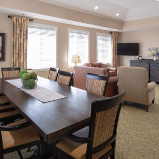 A spacious dining area connected to a living room with modern furnishings and natural lighting.