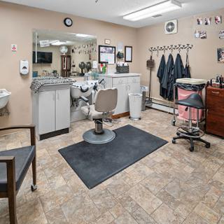A well-organized barber shop interior featuring a central styling chair and various grooming tools.