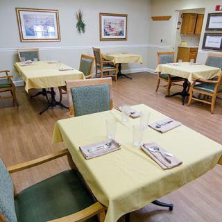 A neatly arranged dining room with tables set for guests.