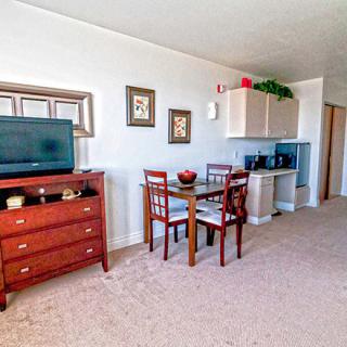 A cozy living room with a TV, dining area, and tasteful decor.