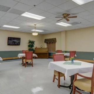 A clean and simple dining area with tables and chairs arranged for guests.