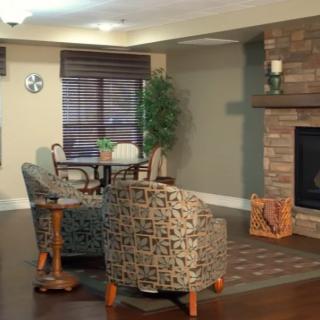 A cozy living room with stylish chairs and a brick fireplace.