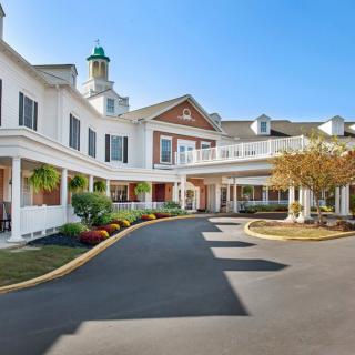 A welcoming entrance to a large residential building with detailed landscaping.