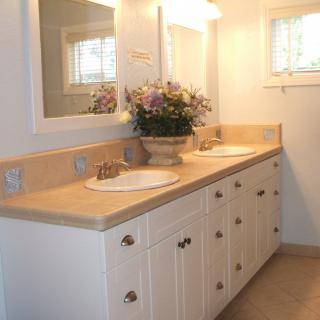 A well-lit bathroom with a double sink vanity and floral decoration.