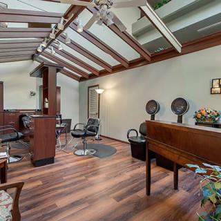 A stylish salon interior with wooden flooring and modern amenities.