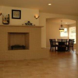 A spacious living area with a fireplace and an adjoining dining space.