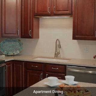 A modern apartment kitchen with wooden cabinets and a clean countertop.