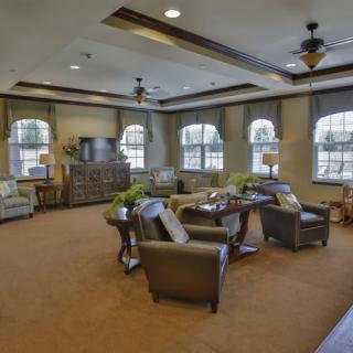 A cozy living room with comfortable seating, a television, and large windows.